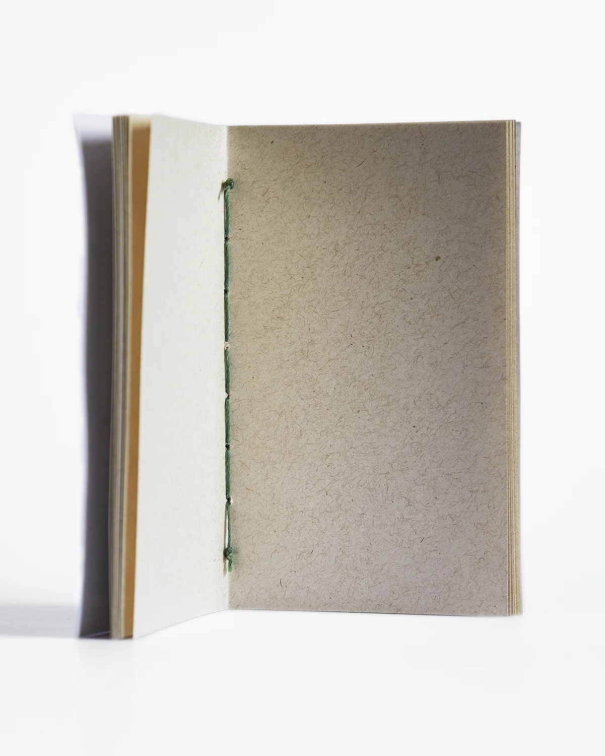 Interior de libreta artesanal encuadernada a mano con hilo verde, papel artesanal Chonta
